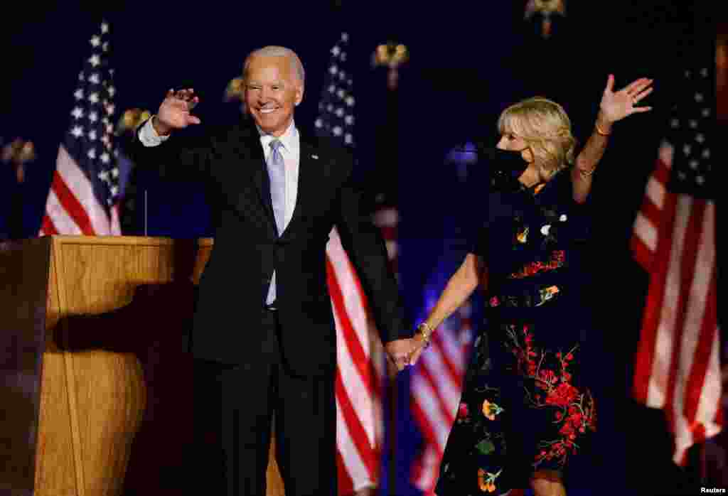 Democratic 2020 U.S. presidential nominee Joe Biden and his wife Jill wave to the crowd after speaking at his election rally, after the news media announced that Biden has won the 2020 election.