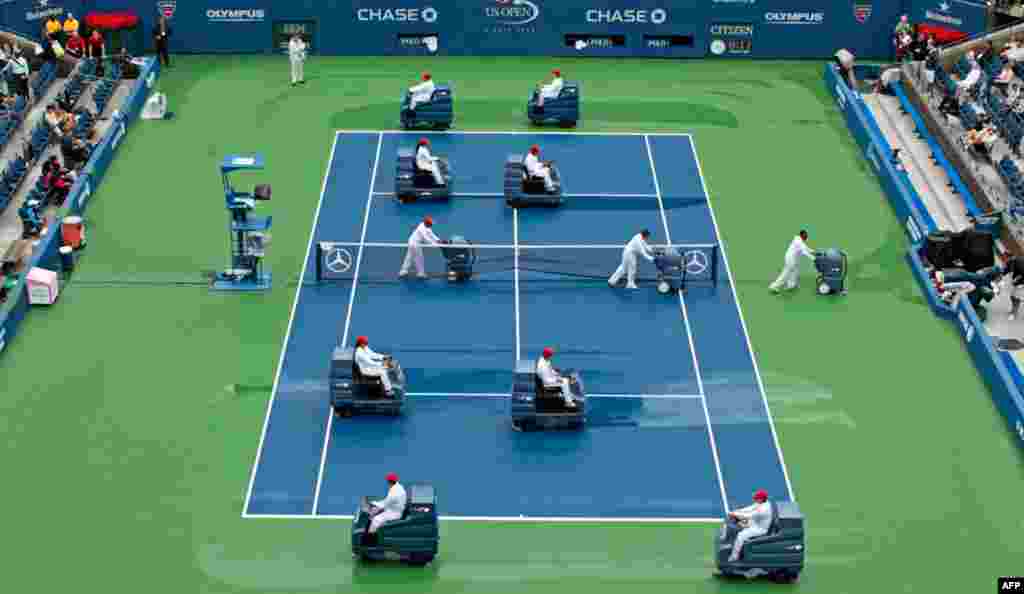 September 7: Court workers remove water from the playing surface of Arthur Ashe Stadium after rain delayed competition in the U.S. Open tennis tournament in New York. REUTERS/Lucy Nicholson