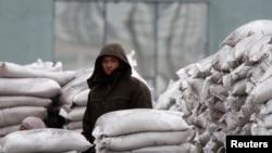 FILE - A man stands among sacks of wheat on the banks of Yalu River near the North Korean town of Sinuiju, opposite the Chinese border city of Dandong, January 29, 2014. (REUTERS/Jacky Chen) 