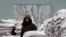 FILE - A man stands among sacks of wheat on the banks of Yalu River near the North Korean town of Sinuiju, opposite the Chinese border city of Dandong, January 29, 2014.