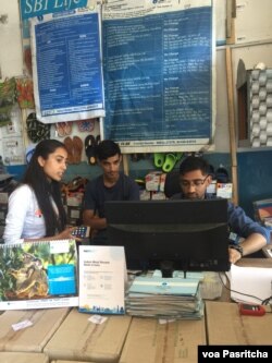 Customers use their phones to make digital payments at the local shop. (A. Pasricha/VOA)