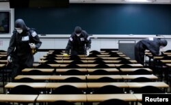FILE - South Korean soldiers clean desks with disinfectant in a classroom of a cram school for civil service exams, following the rise in confirmed cases of coronavirus disease (COVID-19) in Daegu, South Korea, March 15, 2020.