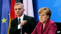 Le président fédéral de la Suisse et chef du Département fédéral des affaires étrangères, Didier Burkhalter et Angela Merkel, chancelière allemande, à Berlin, Allemagne, le 18 février 2014.