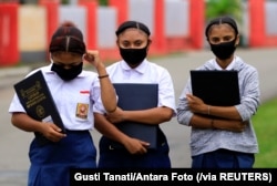 Para pelajar mengenakan masker untuk mencegah penularan virus corona di Jayapura, Papua, 13 Juli 2020. (Foto: Gusti Tanati/Antara Foto via Reuters)