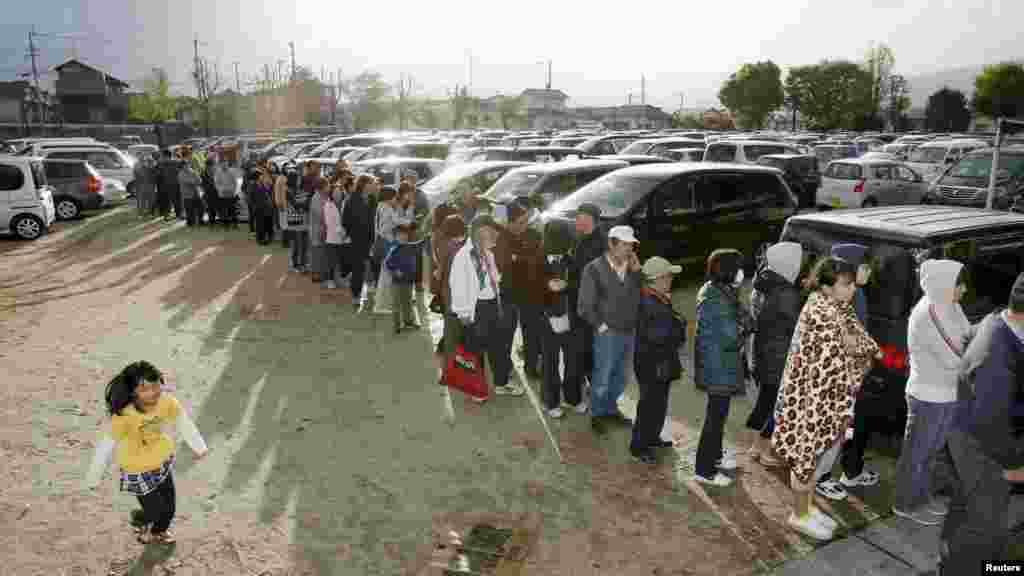 Des habitants font la queue pour obtenir de l&#39;eau et de la nourriture dans une école élémentaire à Mashiki, préfecture de Kumamoto, Japon, 17 avril 2016. Photo prise par&nbsp;Kyodo. &nbsp;