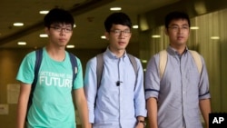 Three Hong Kong student protest leaders, from left, Joshua Wong, Nathan Law and Alex Chow walk out from a magistrate's court in Hong Kong, Monday, Aug. 15, 2016. 