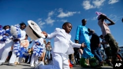 FILE - Young members of the Original Big Seven Junior Steppers dance during a second line at the New Orleans Jazz and Heritage Festival in New Orleans, Friday, May 5, 2017. (AP Photo/Gerald Herbert)
