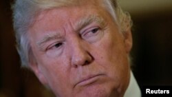 President-elect Donald Trump listens to questions from reporters in the lobby at Trump Tower in New York, Jan. 9. 2017.