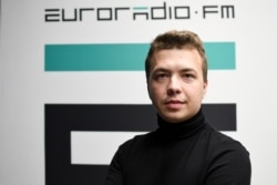 FILE - In this handout photo released by European Radio for Belarus, Belarus journalist Raman Pratasevich poses for a photo in front of euroradio.fm sign in Minsk, Belarus, Nov. 17, 2019.