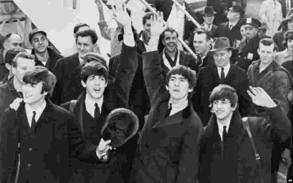 Kundi la Beatles likipungia wapenzi wa muziki baada ya kuwasili uwanja wa ndege wa Kennedy, New York mwaka 1964.