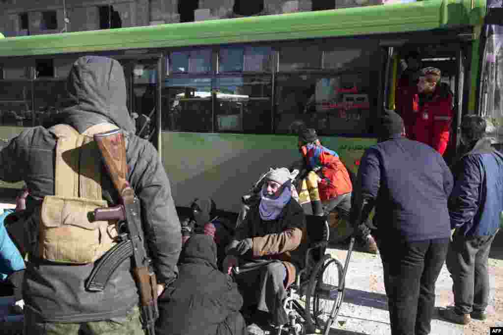 Syrians gather during an evacuation operation of rebel fighters and their families from rebel-held neighborhoods on Dec. 15, 2016 in the embattled city of Aleppo.