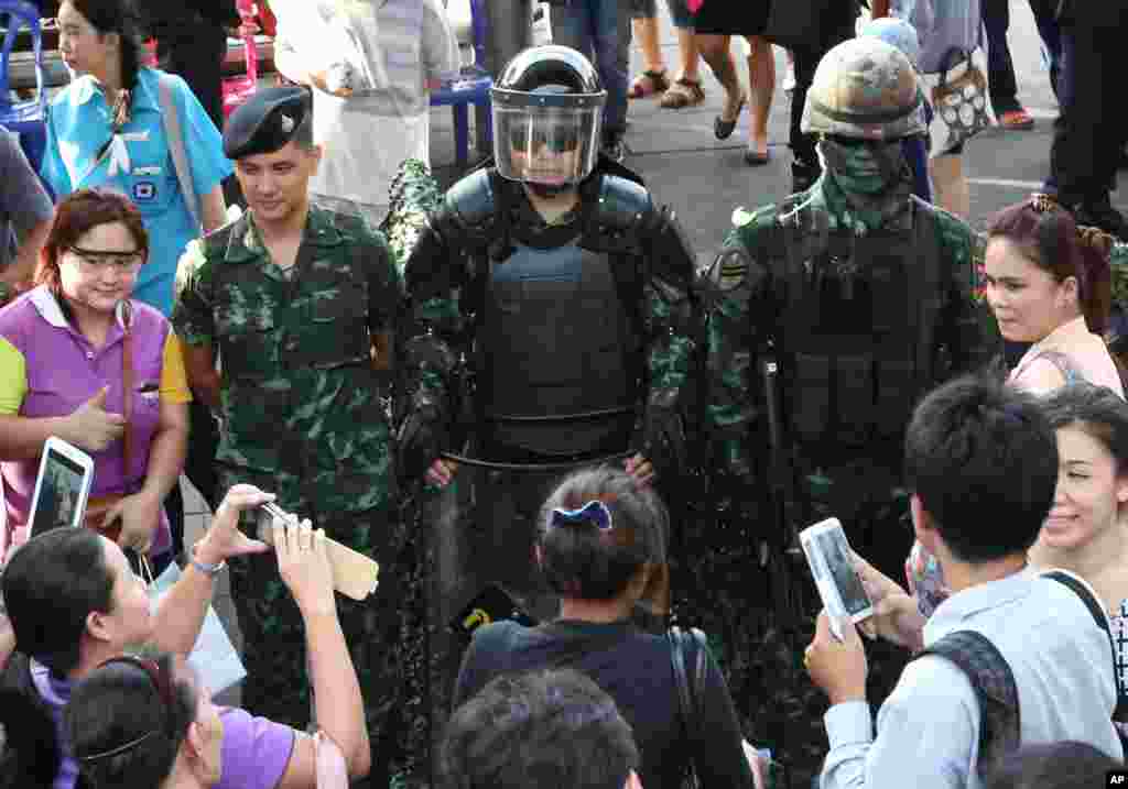 People take photos of Thai special forces officers during an event called 'Return Happiness to Thai People' at Bangkok's Victory Monument, June 4, 2014.