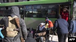 Syrians gather during an evacuation operation of rebel fighters and their families from rebel-held neighborhoods on Dec. 15, 2016 in the embattled city of Aleppo.