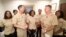 Yeoman First Class LaToya Jones, center, speaks as Chief of Naval Operations Adm. John Richardson, left of center, and Chief of Naval Personnel Adm. Robert Burke, right of center, and other members of the working group listen. The Navy says it will now allow servicewomen to sport ponytails and other hairstyles, reversing a policy that long forbade females from letting their hair down, in a frame grab from a Facebook Live event, July 10, 2018.