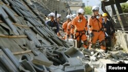 Tim penyelamat dan pemadam kebakaran Jepang memeriksa rumah-rumah yang ambruk akibat gempa di kota Mashiki, Kumamoto, Jepang selatan. 