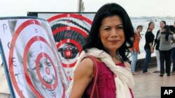 File: Activist and lawyer Seng Chan Theary poses with dartboard posters during a protest in Phnom Penh, Cambodia, Nov. 18, 2012. (AP Photo/Luke Hunt)