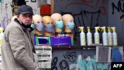 A gray market salesman sells face masks and hand sanitizer at a street corner in Sarajevo on April 22, 2020.