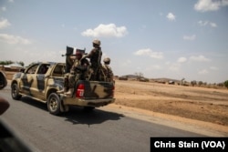 Nigerian soldiers drive along a road in northern Adamawa State, Nigeria on March 26, 2016.