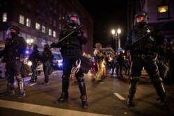 FILE - In this Nov. 4, 2020, photo, police form a perimeter during protests following the Nov. 3 presidential election in Portland, Ore.