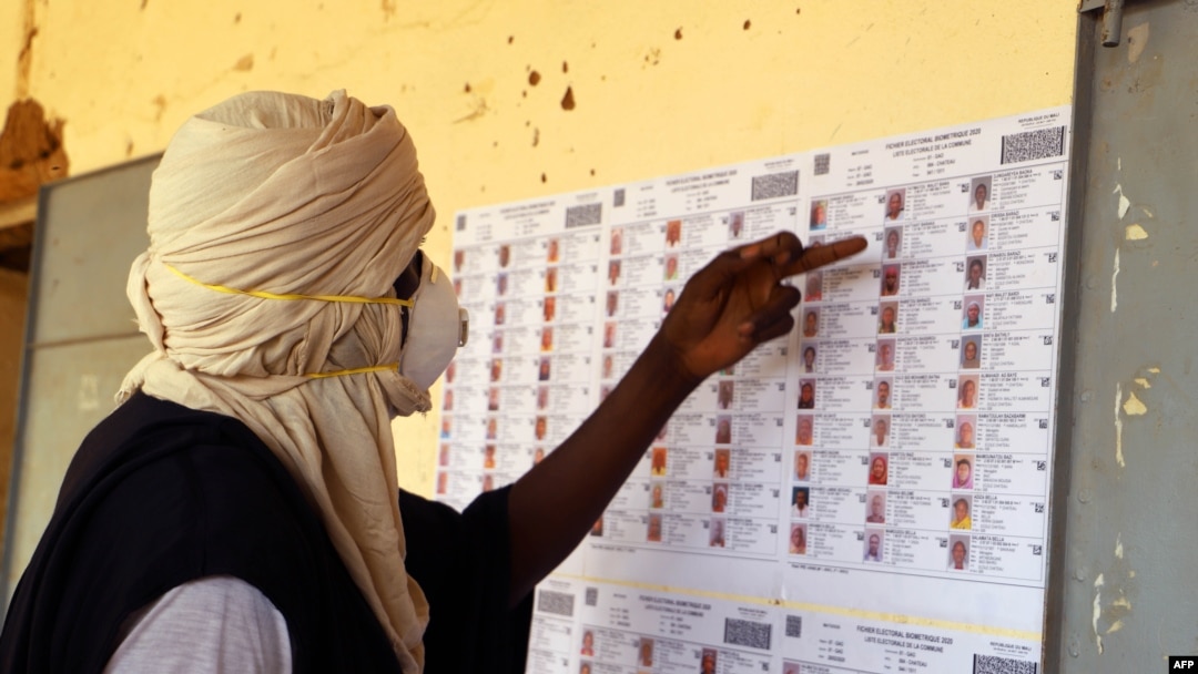 Seorang pemilih yang mengenakan masker memeriksa data pemilih di sebuah tempat pemungutan suara di Gao, Mali, 29 Maret 2020. 