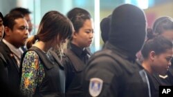 Siti Aisyah (kanan) dan Doan Thi Huong (dua dari kiri), dikawal oleh polisi di Bandara Internasional Kuala Lumpur di Sepang, Malaysia, Selasa, 24 Oktober 2017.