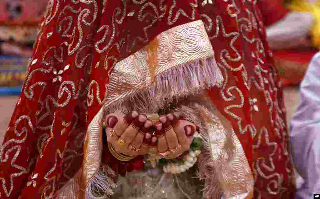 A Muslim bridge prays while she attends the last Friday prayer during the holy fasting month of Ramadan, at the historical Badshahi mosque, in Lahore, Pakistan.