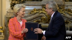 La presidenta de la Comisión Europea, Ursula von der Leyen, a la izquierda, y el presidente de Argentina, Alberto Fernández, intercambian carpetas durante una reunión en la casa de gobierno en Buenos Aires, Argentina, el martes 13 de junio de 2023. 