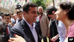 FILE - Greeted by supporters, Selahattin Demirtas, leader of pro-Kurdish Peoples' Democracy Party, smiles as he arrives at his party headquarters in Ankara, Turkey, June 9, 2015.