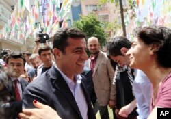 FILE - Greeted by supporters, Selahattin Demirtas, leader of pro-Kurdish Peoples' Democracy Party, smiles as he arrives at his party headquarters in Ankara, Turkey, June 9, 2015.