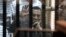 FILE - Ousted Egyptian President Hosni Mubarak, sitting in a defendants cage, waves during a court hearing as his son Gamal, left, in Cairo, Egypt, Wednesday, May 21, 2014.