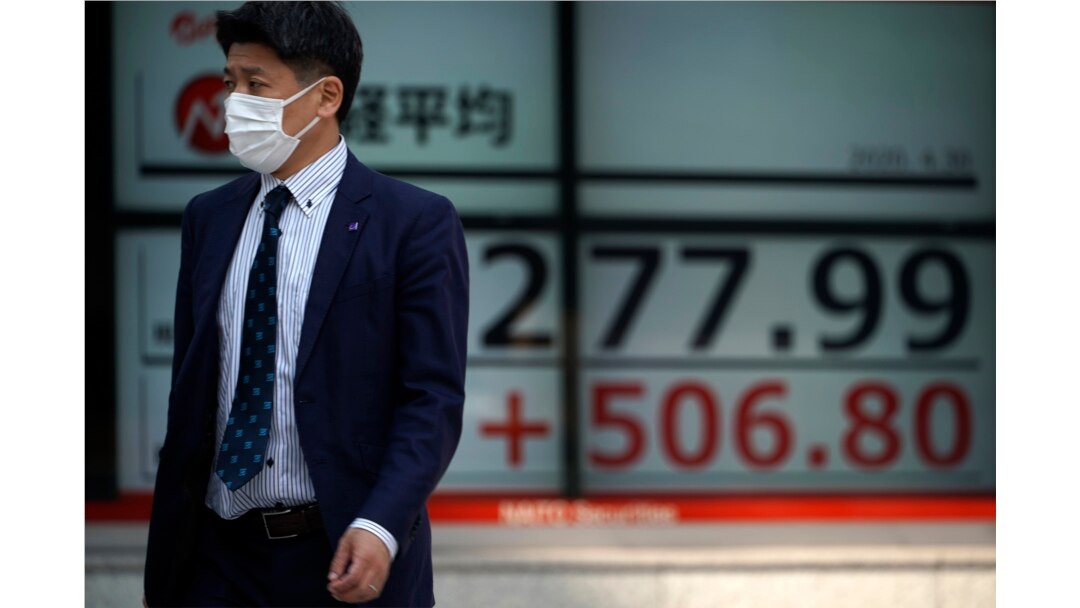 A man walks past an electronic stock board showing Japan's Nikkei 225 index at a securities firm in Tokyo, April 30, 2020.