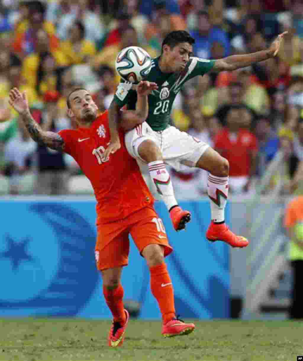 Netherlands' Wesley Sneijder, left, and Mexico's Javier Aquino battle for the ball during the World Cup round of 16 soccer match between the Netherlands and Mexico at the Arena Castelao in Fortaleza, Brazil, Sunday, June 29, 2014. (AP Photo/Wong Maye-E)