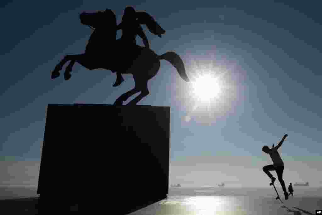 A skateboarder practices near the modern bronze statue of Alexander the Great on his famous horse Bucephalus in the northern port city of Thessaloniki , Greece.