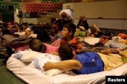 Cuban migrants, waiting for their appointment to request asylum in the U.S., rest at a gym being used as a shelter in Ciudad Juarez, Mexico, March 19, 2019.
