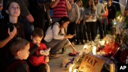 People gather outside the French Consulate in Los Angeles to honor the victims of the Paris terrorist attacks. (AP Photo/Damian Dovarganes)