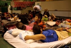 FILE - Cuban migrants, waiting for their appointment to request asylum in the U.S., rest at a gym being used as a shelter in Ciudad Juarez, Mexico, March 19, 2019.