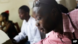 FILE - Momulu Norman, 22, a former child soldier, teaches at a computer school in Monrovia, Liberia.