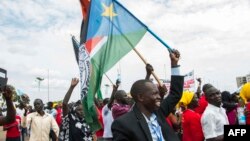 People gather as they wait for the arrival of South Sudan's President Salva Kiir in the capital Juba on Aug. 6, 2018, following the signing in neighboring Sudan of a cease-fire and power-sharing agreement. 