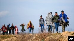 Des migrants marchent sur une route près du poste frontière d'Ipsala à Edirne, à la frontière turco-grecque, le 3 mars 2020.