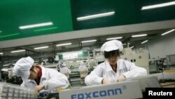 Para pekerja perakit iPhone di dalam pabrik Foxconn di kota Longhua di Guandong Selatan (foto: dok).