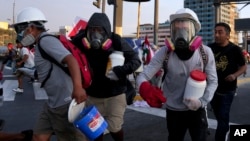 So-called 'deactivators' carry large plastic bottles filled with a mixture of water, baking soda and vinegar, during clashes with police in Lima, Peru, Jan. 26, 2023.