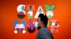 A man wearing a face mask walks in front of a poster recommending people to stay at home, at a department store in Berlin, Germany, April 20, 2020. 