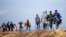 Des migrants marchent sur une route près du poste frontière d'Ipsala à Edirne, à la frontière turco-grecque, le 3 mars 2020.