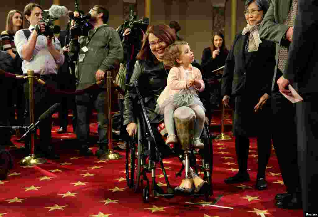 Senator Tammy Duckworth membawa putrinya Abigail dalam simulasi pengambilan sumpah bersama Wakil Presiden AS Joe Biden pada pembukaan Kongres ke-115 di Capitol Hill, Washington, D.C.&nbsp;(Reuters/Joshua Roberts)