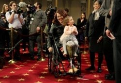 Senator Tammy Duckworth (D-IL) carries her daughter Abigail during a mock swearing in with U.S. Vice President Joe Biden during the opening day of the 115th Congress on Capitol Hill in Washington, Jan. 3, 2017.