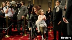 Senator Tammy Duckworth (D-IL) carries her daughter Abigail during a mock swearing in with U.S. Vice President Joe Biden during the opening day of the 115th Congress on Capitol Hill in Washington, Jan. 3, 2017. 