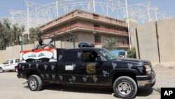 Iraqi security forces guard the entrance to a sports complex being built by a Turkish construction company, in the Shi'ite district of Sadr City, Baghdad, Sept. 2, 2015.