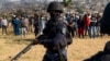 Un policier armé patrouille alors que le ministre de la police Bheki Cele visite Phoenix, un quartier gravement touché par les troubles et les tensions raciales près de Durban, en Afrique du Sud, le 17 juillet 2021.