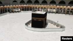 FILE - Kaaba at the Grand Mosque is nearly empty of worshippers after the Saudi authority suspended umrah (the Islamic pilgrimage to Mecca) amid fear of the coronavirus outbreak, at Muslim holy city of Mecca, Saudi Arabia, March 6, 2020. 