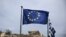 A European Union flag flutters as the ancient Parthenon temple is seen in the background in Athens, June 1, 2015. 